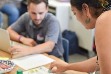 A teacher working on a lesson plan with another teacher